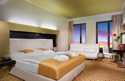 Grandior Hotel Prague room. Modern interior, double bed, sofa, sunset view. Perfect for gay couples visiting Old Town. Gay-friendly hotel.