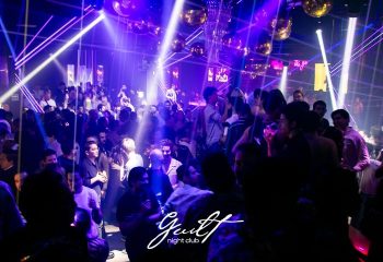 Guilt Night Club, a gay bar in Mexico. The dance floor is packed with people under disco balls and purple lights.