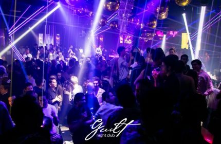 Guilt Night Club, a gay bar in Mexico. The dance floor is packed with people under disco balls and purple lights.