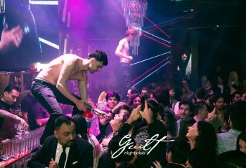 Guilt Night Club, a gay bar in Mexico. A shirtless man stands on the bar with a fire extinguisher, entertaining the crowd. Nightlife.