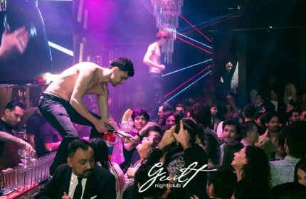Guilt Night Club, a gay bar in Mexico. A shirtless man stands on the bar with a fire extinguisher, entertaining the crowd. Nightlife.