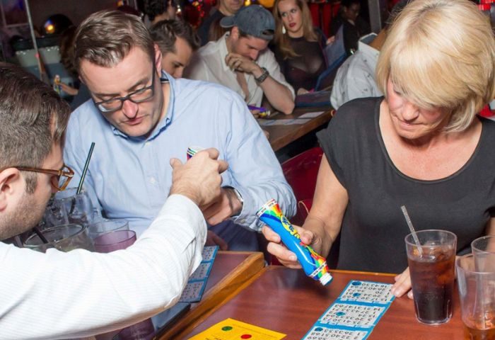 People playing bingo at Hamburger Mary's WeHo, a popular gay bar in West Hollywood. Bingo cards, drinks, and dabbers on the table.
