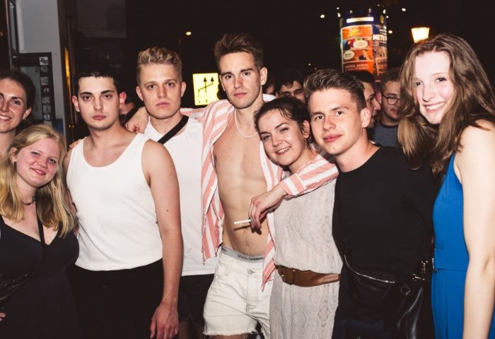 Group of friends at Toldi Club, Budapest. Gay travel nightlife scene with young adults enjoying a party. Budapest gay scene.