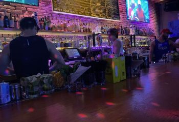 Hi Tops Bar interior. Bartenders at work, drinks being prepared. Gay bar atmosphere with colorful lighting. Hi-Tops-Bar.jpg