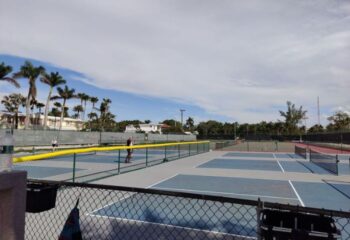 Tennis courts at Higgs Beach in Key West, a popular gay travel destination. Palm trees and blue skies in the background.