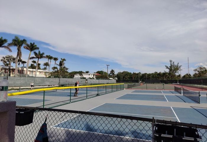 Tennis courts at Higgs Beach in Key West, a popular gay travel destination. Palm trees and blue skies in the background.