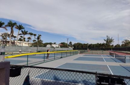 Tennis courts at Higgs Beach in Key West, a popular gay travel destination. Palm trees and blue skies in the background.