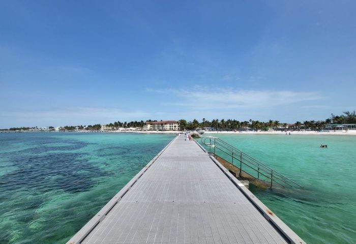 Higgs Beach pier in Key West, a gay-friendly travel destination. Turquoise water, palm trees, and white sand. Ideal for gay cruises.