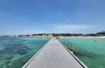 Higgs Beach pier in Key West, a gay-friendly travel destination. Turquoise water, palm trees, and white sand. Ideal for gay cruises.