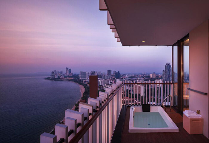 Hilton Pattaya luxury beachfront hotel view at dusk. Popular gay hotel in Pattaya with balcony jacuzzi overlooking the city and ocean.