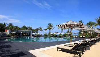 Hilton Phuket Arcadia Resort & Spa pool view. Perfect gay honeymoon hotel in Phuket with pool, beach umbrellas, and lounge chairs.