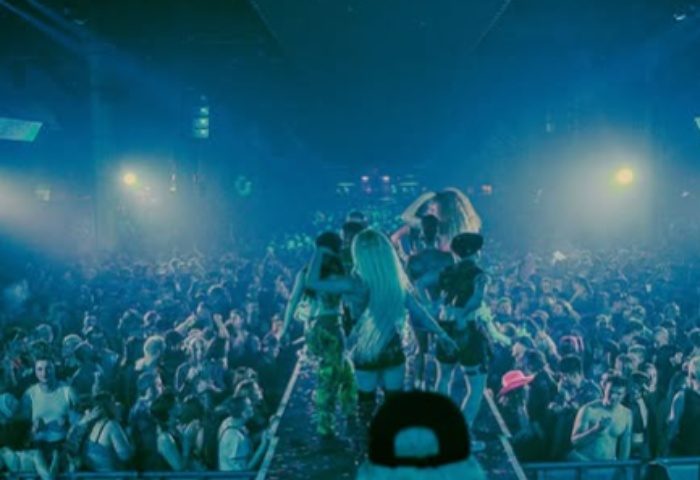Homoelectric Manchester crowd. Gay club event with performers on stage and a large, excited audience. Nightlife scene for gay men's travel.