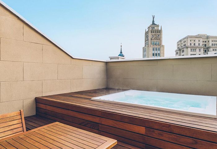 Iberostar Las Letras Gran Vía honeymoon suite in Madrid. Hot tub on a wooden deck with city views. Gay-friendly hotel in the city center.