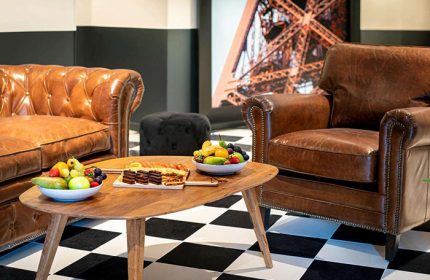 Mercure Paris Centre Tour Eiffel hotel lounge area. Honeymoon hotel ideas in Paris. Leather sofa, armchair, Eiffel Tower art, fruit.