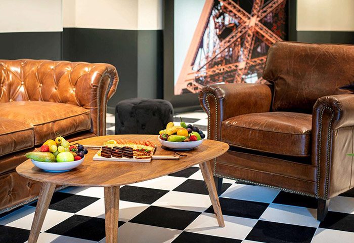 Mercure Paris Centre Tour Eiffel hotel lounge area. Honeymoon hotel ideas in Paris. Leather sofa, armchair, Eiffel Tower art, fruit.