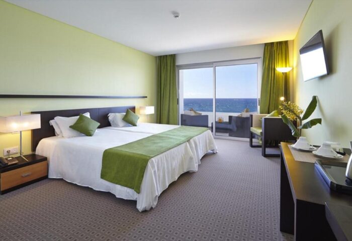 Aqua Natura Madeira hotel room. Gay-friendly hotel with sea view balcony, double bed, and modern decor. Ideal for gay travel in Madeira.