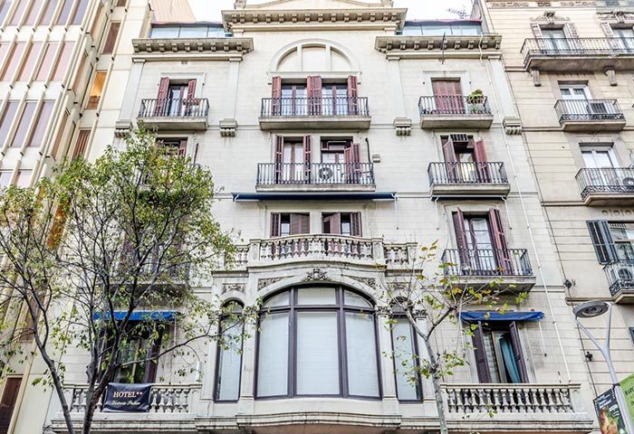 Hotel Victoria Palace, best gay hotel in Barcelona city center near Gaixample. Building facade with balconies and shutters.