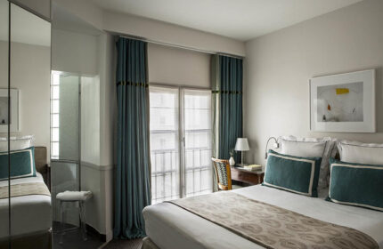 Hotel de la Place du Louvre room: Perfect gay honeymoon hotel this year. Bedroom with double bed, desk, and blue curtains. Paris hotel.