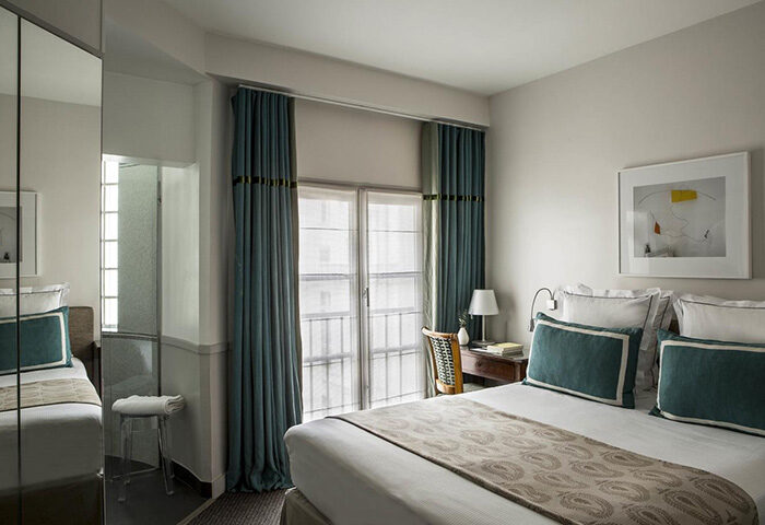 Hotel de la Place du Louvre room: Perfect gay honeymoon hotel this year. Bedroom with double bed, desk, and blue curtains. Paris hotel.