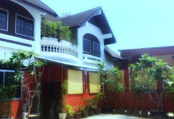 House of Male Chiagn Mai Gay Sauna: Exterior view of the gay sauna in Chiang Mai, Thailand. Balcony, plants, and red fence visible.