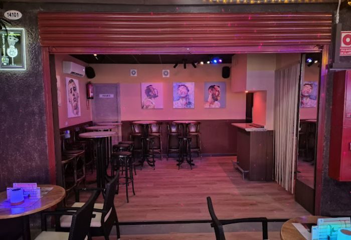 Hummel Hummel Gay Bar in Gran Canaria. Interior view of the bar with tables, chairs, artwork, and a relaxed atmosphere. Gay travel.