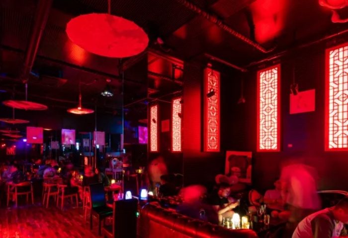 Shanghai gay bar, Hunt, with red lighting, Asian decor, and patrons. A popular gay travel destination known for its nightlife.