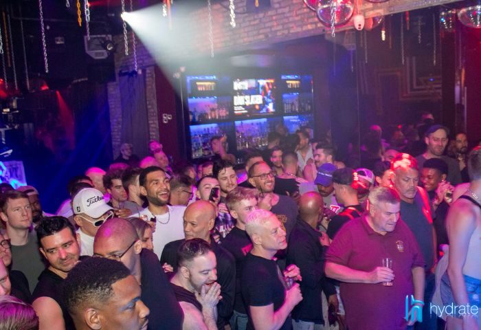 Crowd at Hydrate Nightclub, a popular gay bar in Chicago. Men are socializing and enjoying the lively atmosphere. Nightlife scene.