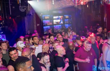 Crowd at Hydrate Nightclub, a popular gay bar in Chicago. Men are socializing and enjoying the lively atmosphere. Nightlife scene.
