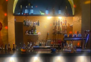 Il Diavolo Dentro bar in Rome: Bottles of liquor and beer taps line the bar at this gay-friendly travel destination. Nightlife in Italy.