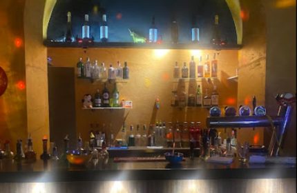 Il Diavolo Dentro bar in Rome: Bottles of liquor and beer taps line the bar at this gay-friendly travel destination. Nightlife in Italy.