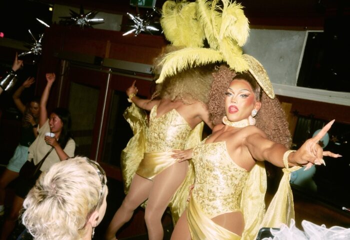 Imperial Erskineville Sydney drag show. Drag queens in gold costumes perform for a crowd. Gay travel advice for Sydney's nightlife.