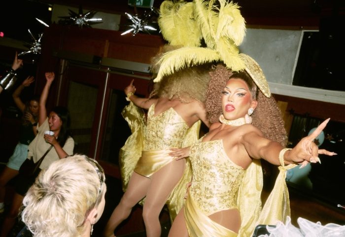 Imperial Erskineville Sydney drag show. Drag queens in gold costumes perform for a crowd. Gay travel advice for Sydney's nightlife.