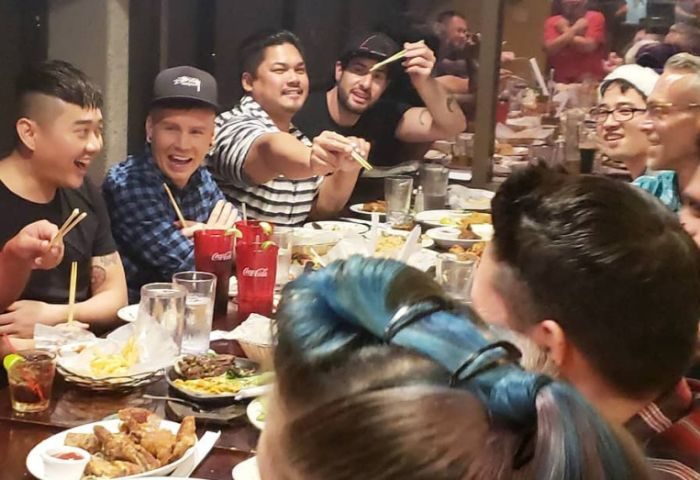 Gay men enjoy food at In Between Waikiki, a gay bar in Honolulu. Karaoke nights are popular. Travel advice for LGBTQ+ visitors.