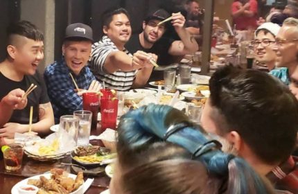 Gay men enjoy food at In Between Waikiki, a gay bar in Honolulu. Karaoke nights are popular. Travel advice for LGBTQ+ visitors.