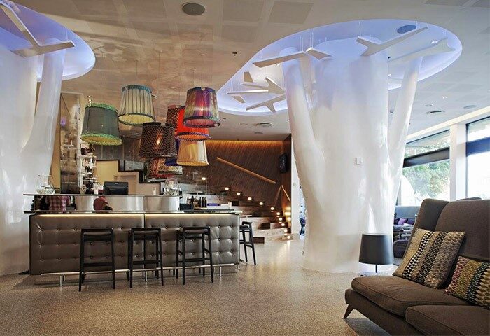 Scandic Copenhagen's gay-friendly hotel bar. Modern design with unique lighting, bar stools, and a cozy lounge area. Perfect for gay travel.