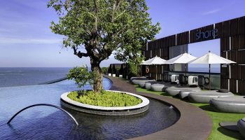 Hilton Pattaya's rooftop infinity pool, an Instagram-perfect spot near gay nightlife. Tree, ocean view, and stylish bar for gay travelers.