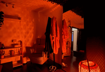 Interior of a spa in Dublin, Ireland. Focus on robes, chair, mirror, and warm lighting. Gay massage travel destination.