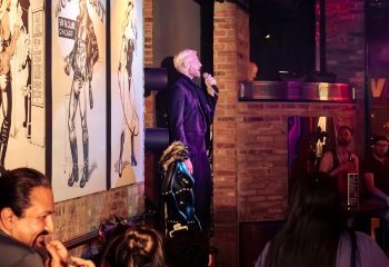 Singer performing at Jackhammer, a gay bar party in Chicago. The venue features brick walls and leather art. Nightlife scene.