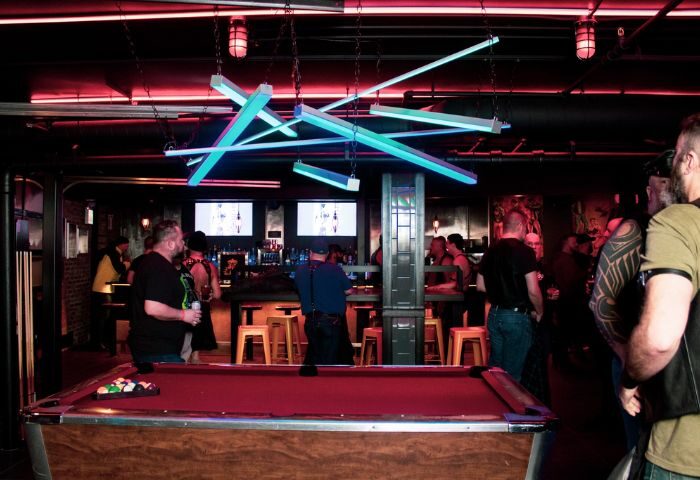 Jackhammer gay bar party in Chicago: Pool table and patrons at a popular gay bar, with unique lighting and a lively atmosphere.