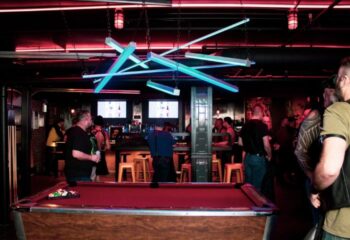 Jackhammer gay bar party in Chicago: Pool table and patrons at a popular gay bar, with unique lighting and a lively atmosphere.