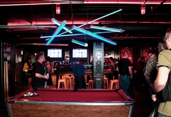 Jackhammer gay bar party in Chicago: Pool table and patrons at a popular gay bar, with unique lighting and a lively atmosphere.
