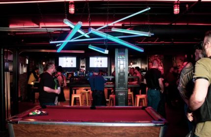 Jackhammer gay bar party in Chicago: Pool table and patrons at a popular gay bar, with unique lighting and a lively atmosphere.