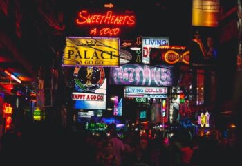 Night scene of Jomtien Complex Walking Street. Neon signs for bars and gogos, including Sweethearts, Palace, and Crazy House. Gay nightlife.