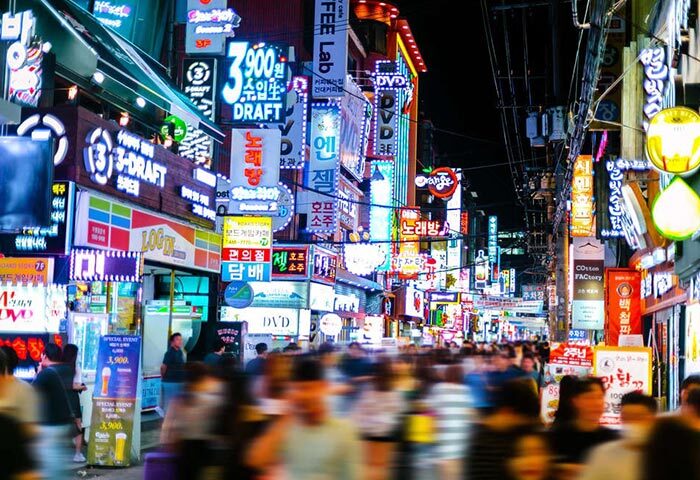 Night scene of Jongno Gay Street in Seoul. Crowded street with bright neon signs, bars, and street food vendors. A popular gay bar hub in Seoul.