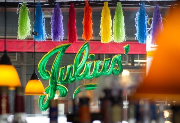 Julius' Gay Bar in New York. View of the bar's sign with rainbow tassels. A popular gay travel destination in NYC's Greenwich Village.