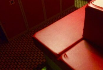 K-Men Club Rome locker room. Red lockers and a red bench in a gay sauna. Gay travel advice for men.