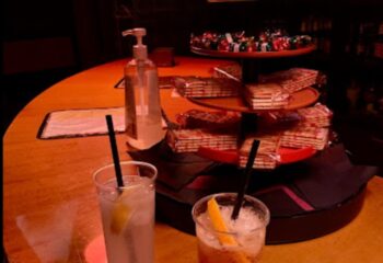 K-Men Club Rome bar: Cocktails, snacks, and hand sanitizer on the bar. Gay travel in Rome. Nightlife scene. Drinks with lemon slices.