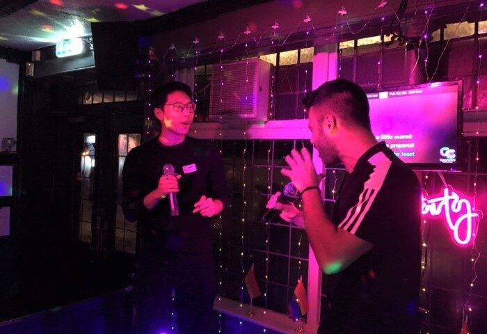 Karaoke night at The Kings Arms Soho, a popular gay bar in London near the Sweatbox gay sauna. Two men sing with microphones under neon lights.