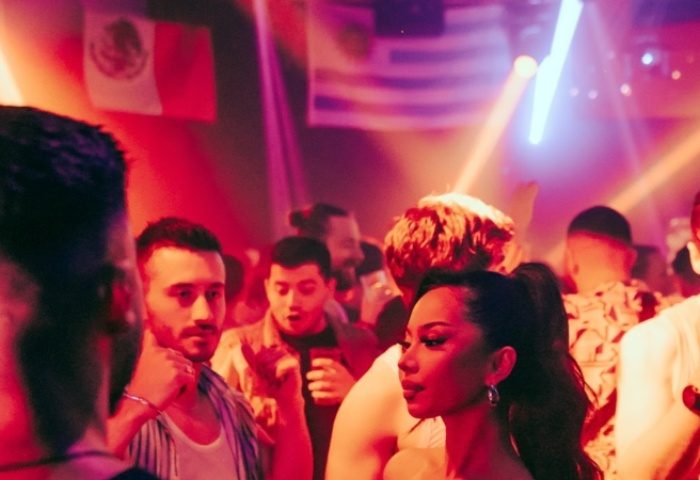Gay nightlife in Sydney: Kinselas Bar scene with diverse crowd, vibrant lights, and international flags. Gay travel destination.