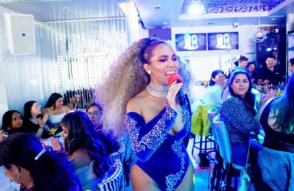 Drag queen performs at Kit Kat Lounge, a gay supper club in Chicago. Partygoers watch the show in the vibrant, upscale venue.